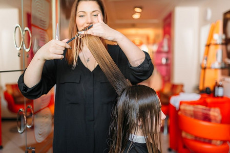 女发型师经营梳子，女发型师在美发沙龙。发型制作在美容工作室