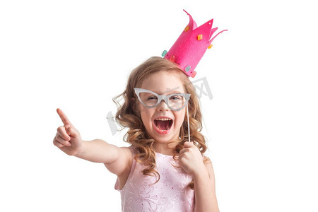 聪明的公主会说话。有趣的公主女孩，穿着粉色连衣裙，戴着王冠，手里拿着派对眼镜，竖起手指说着聪明的话