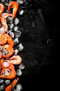 加冰块摄影照片_加冰块的虾。在黑板上。加冰块的虾。