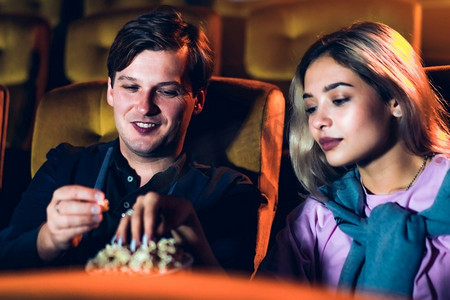 高加索情人喜欢看电影，一起在电影院吃爆米花