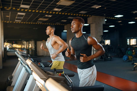 两名运动员在跑步机上跑步，在体育馆训练。健身锻炼在体育俱乐部，健康的生活方式，健身