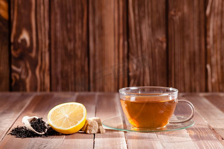 文字框背景摄影照片_红茶与柠檬和红糖方块上的木桌，地方的文字。各种各样的美食