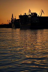 港口剪影摄影照片_港口和鹤反对红色日落背景在夏天