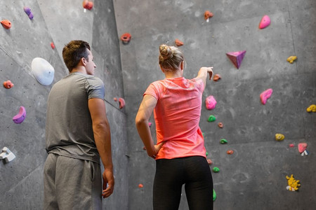 健身，极限运动和抱石概念—男子和妇女在室内攀岩健身房锻炼。男人和女人在室内攀岩健身房锻炼