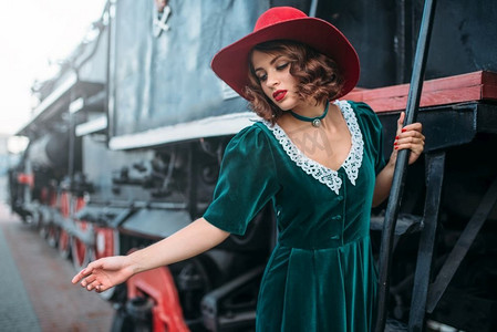 女人在红帽子的老式蒸汽机车。旧火车铁路引擎，铁路旅程 