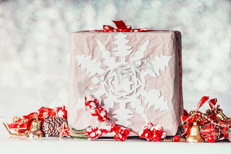 手工制作的圣诞礼盒，纸质雪花和红色装饰的波克背景，正视