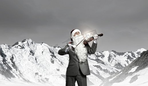 圣诞老人拉小提琴。戴着圣诞帽、留着胡子拉小提琴的商人