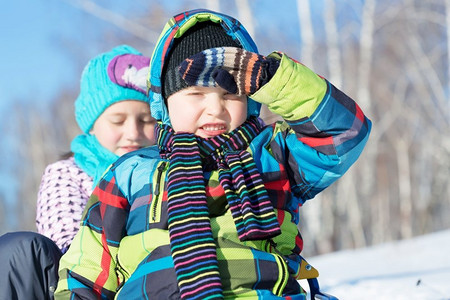冬天的乐趣。男孩和女孩享受雪橇乘坐在美丽的多雪的冬季公园