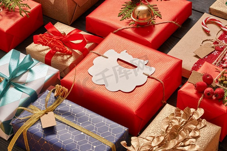 圣诞节深色摄影照片_在深色木质背景的盒子里，创造性地包装和装饰圣诞礼物。平躺着。