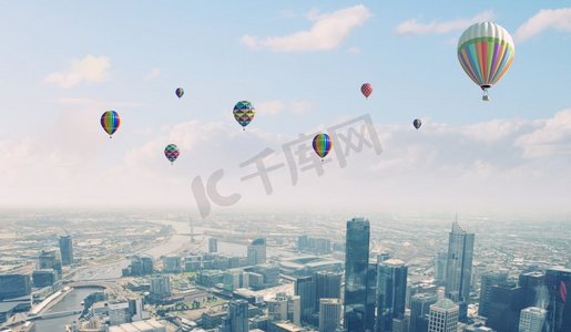 飞翔的气球。五颜六色的浮空器在现代城市上空的晴空中飞舞