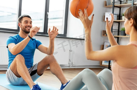 健身、运动、健康生活理念--幸福夫妻在家中带球锻炼。幸福的夫妻在家中带球锻炼