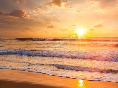 日出与升起的太阳在早晨海滩。有镜头闪光和光线泄漏。海滩上的日出