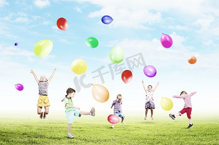 顽皮摄影照片_顽皮的孩子抓气球。一群快乐的孩子玩着五颜六色的气球
