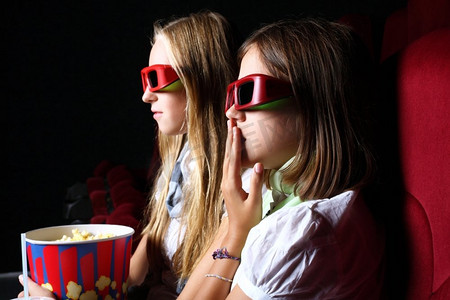 两个年轻女孩在电影院看电影