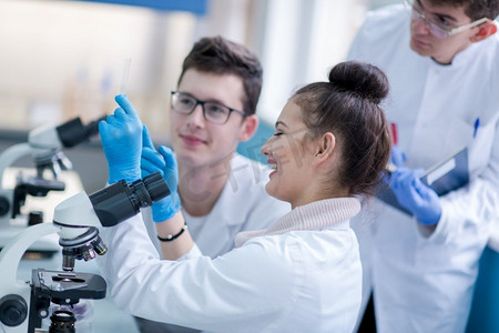 一群年轻的医学生在化学实验室一起做研究，大学生在室内团队合作