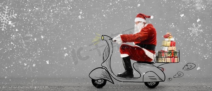 新年送礼物摄影照片_滑板车上的圣诞老人。雪灰色背景下骑着滑板车送圣诞或新年礼物的圣诞老人