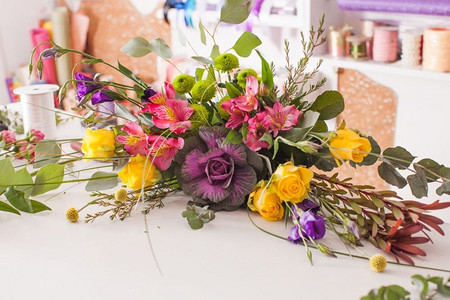 花商用五颜六色的花朵制作时尚的花束。花商制作花束