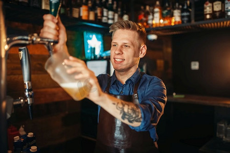 男酒保在吧台倒啤酒.