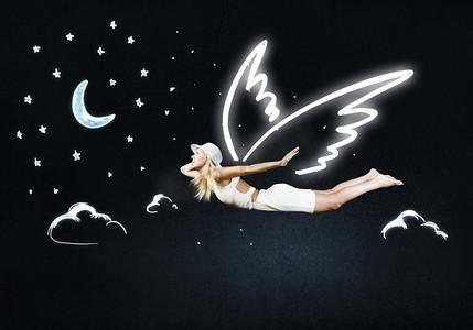 天使女孩飞得很高。在黑暗的天空背景上画着天使翅膀的可爱女孩