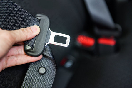 锁车摄影照片_驾驶前坐在车里的汽车安全带/手系好汽车的安全带