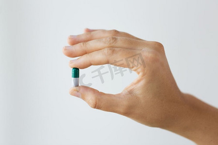 药物,营养补充剂和人的概念-手持药物胶囊的特写.