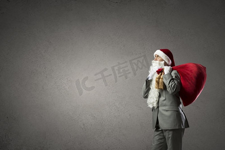 戴着圣诞帽的商人，背后有红色的礼包