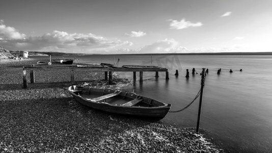 停泊在舰队泻湖的小船的美丽的黑白日落风景图象在英国多塞特郡