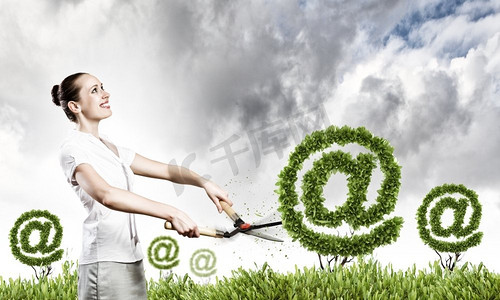 电子邮件概念。年轻有吸引力的女商人切割草坪的形状的电子邮件符号