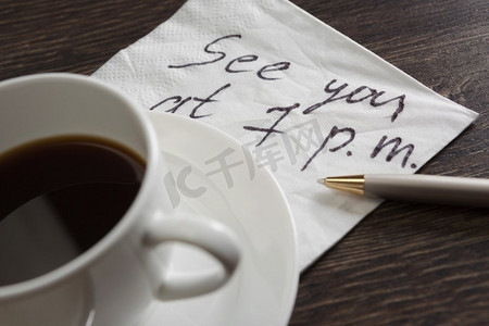 约定浪漫的约会。纸巾和木桌上的一杯咖啡上写着浪漫的信息