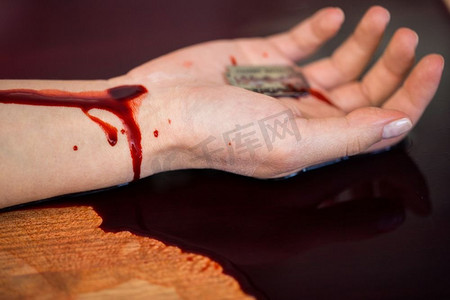 自杀,死亡和人的概念 - 犯罪现场地板上沾满鲜血的死去女人手的特写