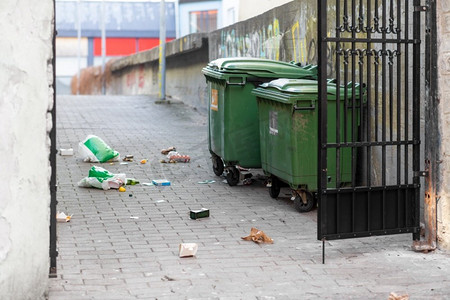垃圾、环境和废物处理概念——在杂乱的城市街道或庭院上的垃圾箱。杂乱的城市街道或庭院上的垃圾箱