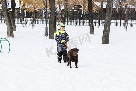 学龄儿童与狗在冬季公园。我和我最好的朋友