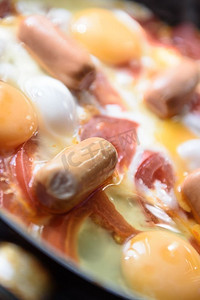 热锅上的煎蛋配香肠和西红柿，做早餐