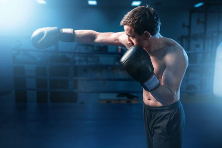 肌肉拳击手在体育馆训练黑手套。拳击训练，男子运动