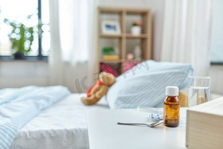 保健概念—桌上有药，床上有泰迪熊玩具。桌上的药和床上的泰迪熊在家里