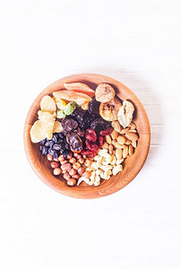干果和坚果放在木桌上的碗里。复制空间背景-关闭健康的糖果。干果和坚果