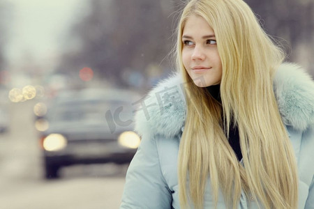 冷行人摄影照片_穿着冬季公路车辆的年轻女子行人