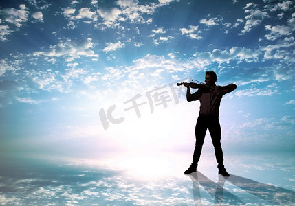 男人在高空拉小提琴的剪影。男子小提琴家