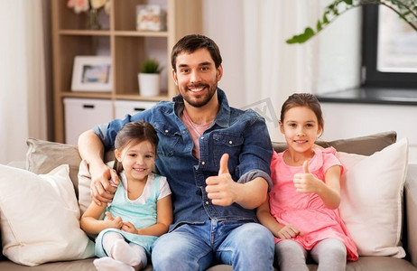 家庭，童年和父亲的概念—快乐的父亲与女儿竖起大拇指在家里。父亲与女儿显示大拇指在家里
