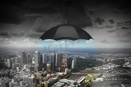 天空中有一把黑色的雨伞。城市上空下雨的天空下的旧黑色雨伞