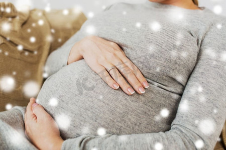 怀孕，人和母亲的概念--雪地里肚子大的孕妇的特写。大腹便便的孕妇特写