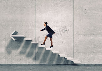 在职业阶梯上往上爬。年轻女商人走上楼梯，象征着成长和进步