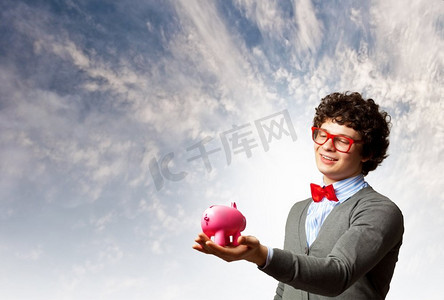 一位年轻的商人手里拿着钱箱。戴着红色眼镜的年轻商人手持钱箱的形象