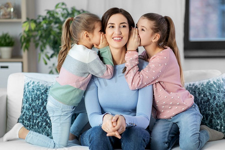 人，家庭和概念—快乐的母亲和两个女儿在家里八卦。快乐的母亲和女儿八卦在家里