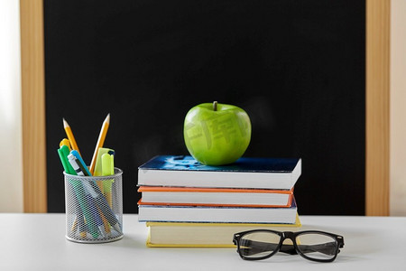 教育和学习概念-书本、苹果、黑板和学习用品放在家里的桌子上。书本、苹果和学习用品放在家里的桌子上