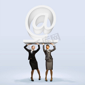 电子邮件概念。两个女商人拿着符号的形象。伙伴与凝聚力