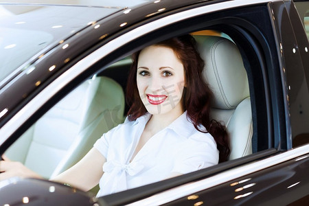 车里的年轻女人有吸引力的年轻女子坐在汽车在汽车中心