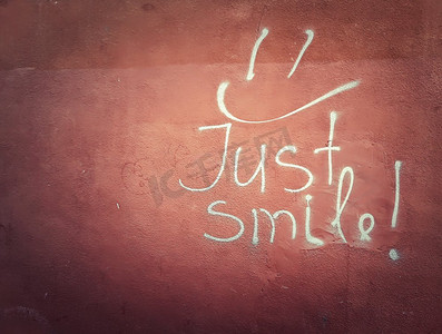 只需在红色的墙上写上微笑，在混凝土质地上涂鸦白色的笑脸符号。