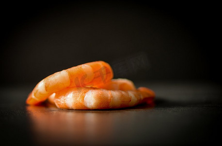 螃蟹堆摄影照片_一堆煮熟的海鲜虾在黑色的深色背景上