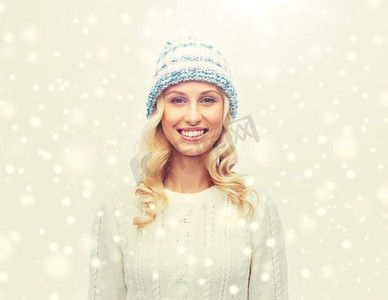 冬天、时尚、圣诞节和人们的概念--戴着冬帽、毛衣和手套微笑的年轻女子。戴着冬帽、穿着毛衣的微笑年轻女子